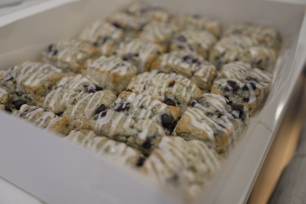 A full bakery box of glazed blueberry scones, packed for pickup.